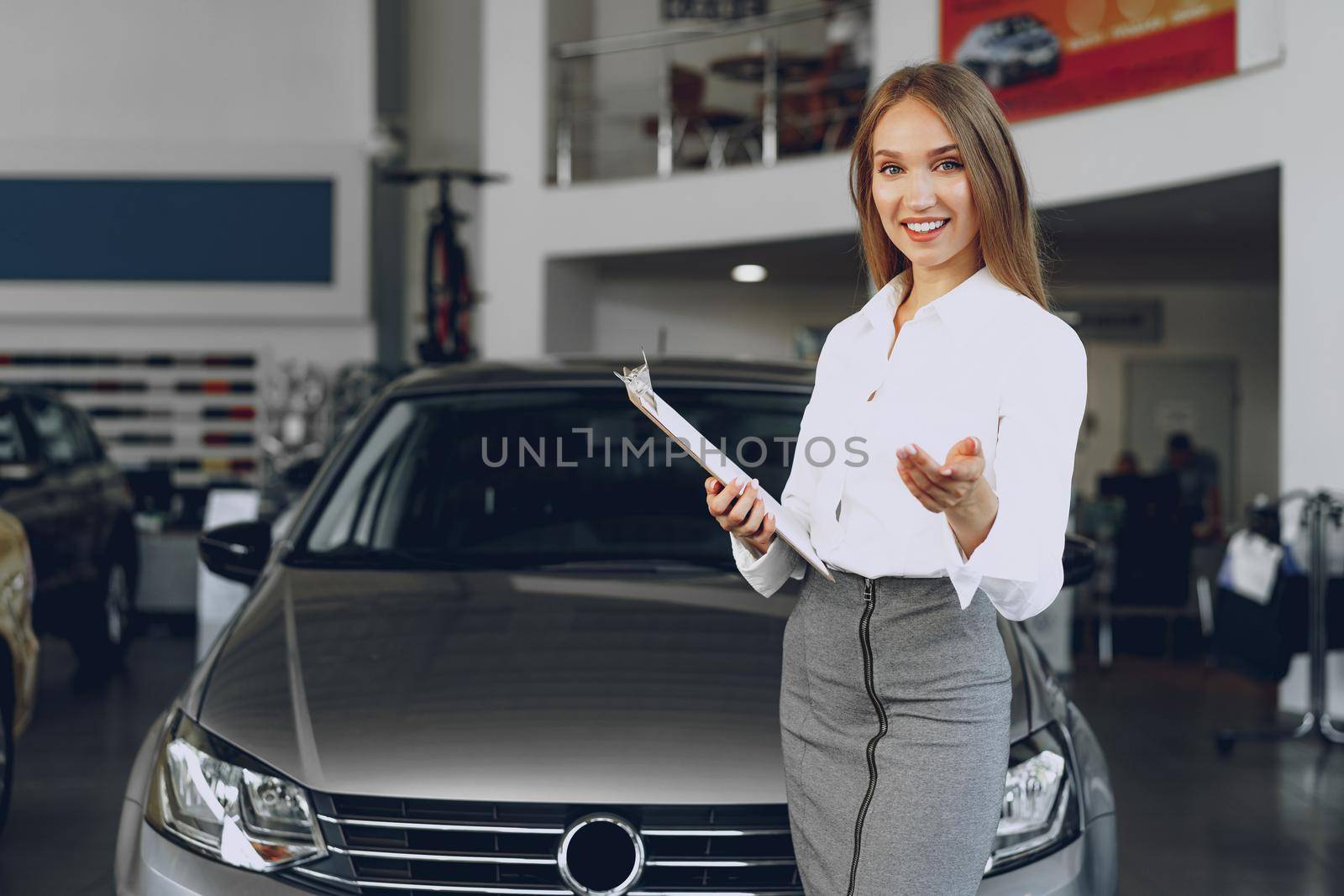 Happy beautiful young woman car dealer in showroom close up