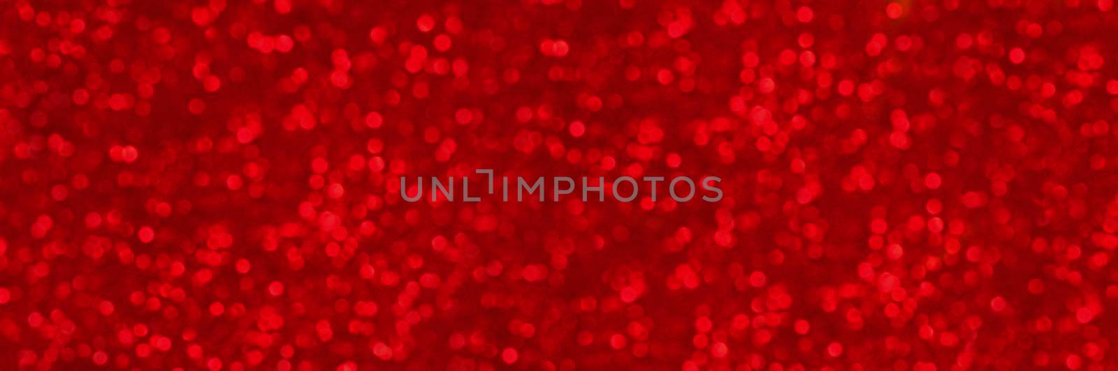 Abstract shiny glitter christmas or new year background. Ruby glitter background with sparkling texture. Red shimmering light, sequins sparks and glittering glow foil background. Long banner or poster