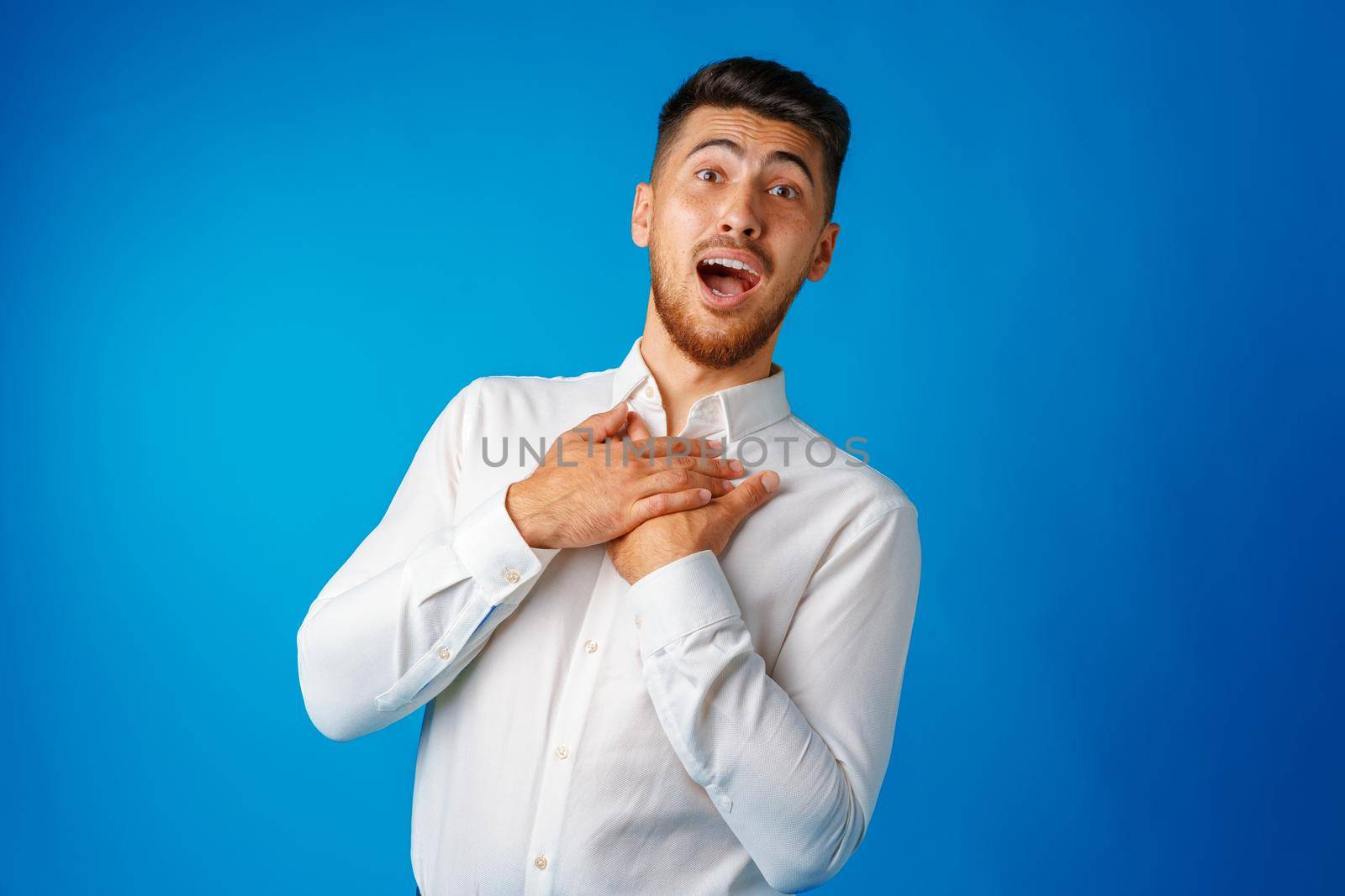 Amazed and confused bearded young man looks with astonishment, portrait .