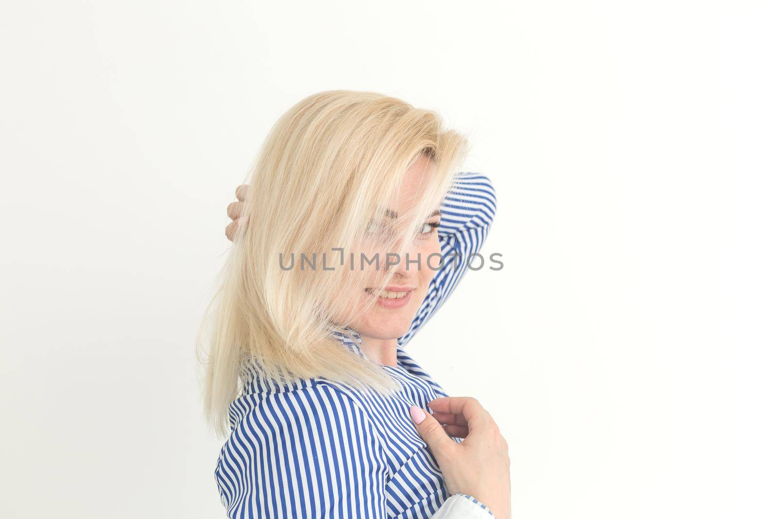 Portrait of emotive good-looking caucasian woman laughing while looking aside and standing against white background.