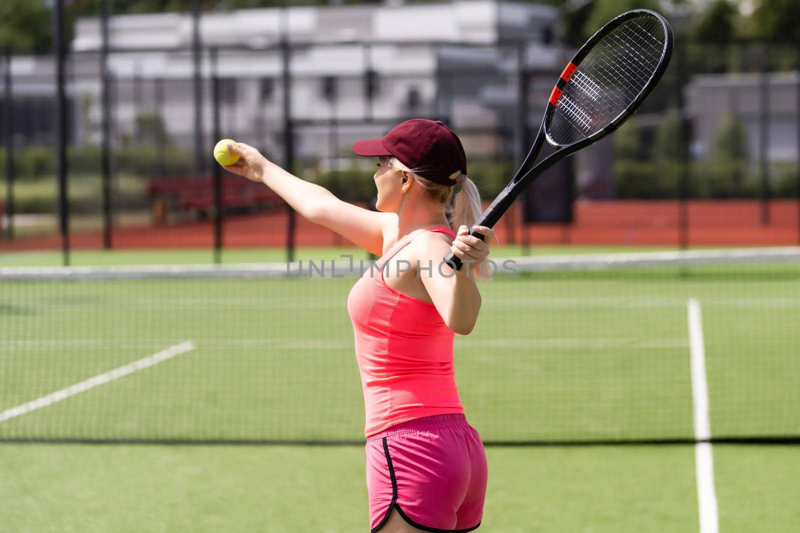 Pretty sportswoman with racquet at the tennis court. Healthy lifestyle