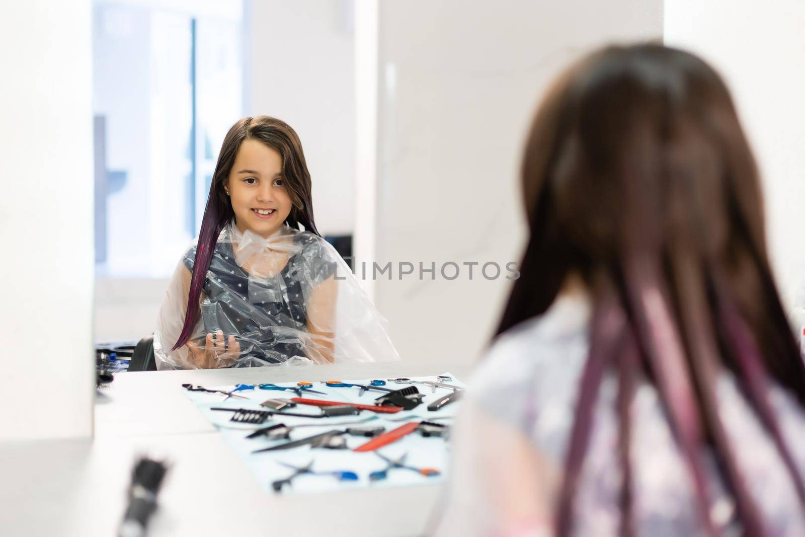 little girl dyes her hair purple in a hairdressing salon by Andelov13