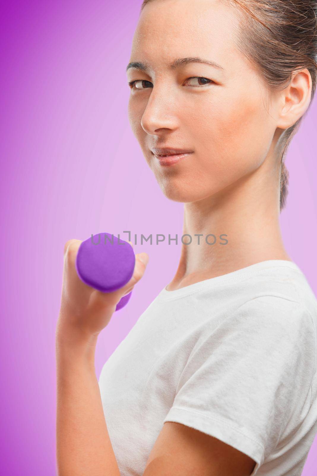 Woman exercises with a dumbbell, side view