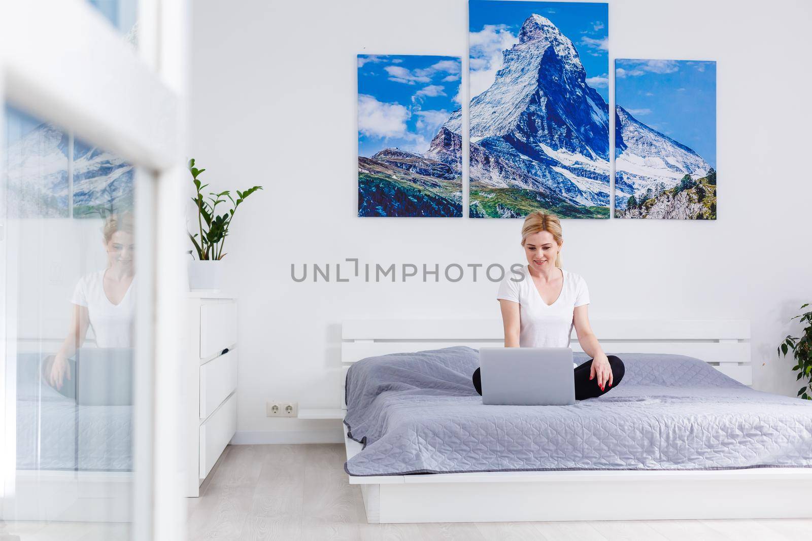A smiling woman in front of her laptop at home