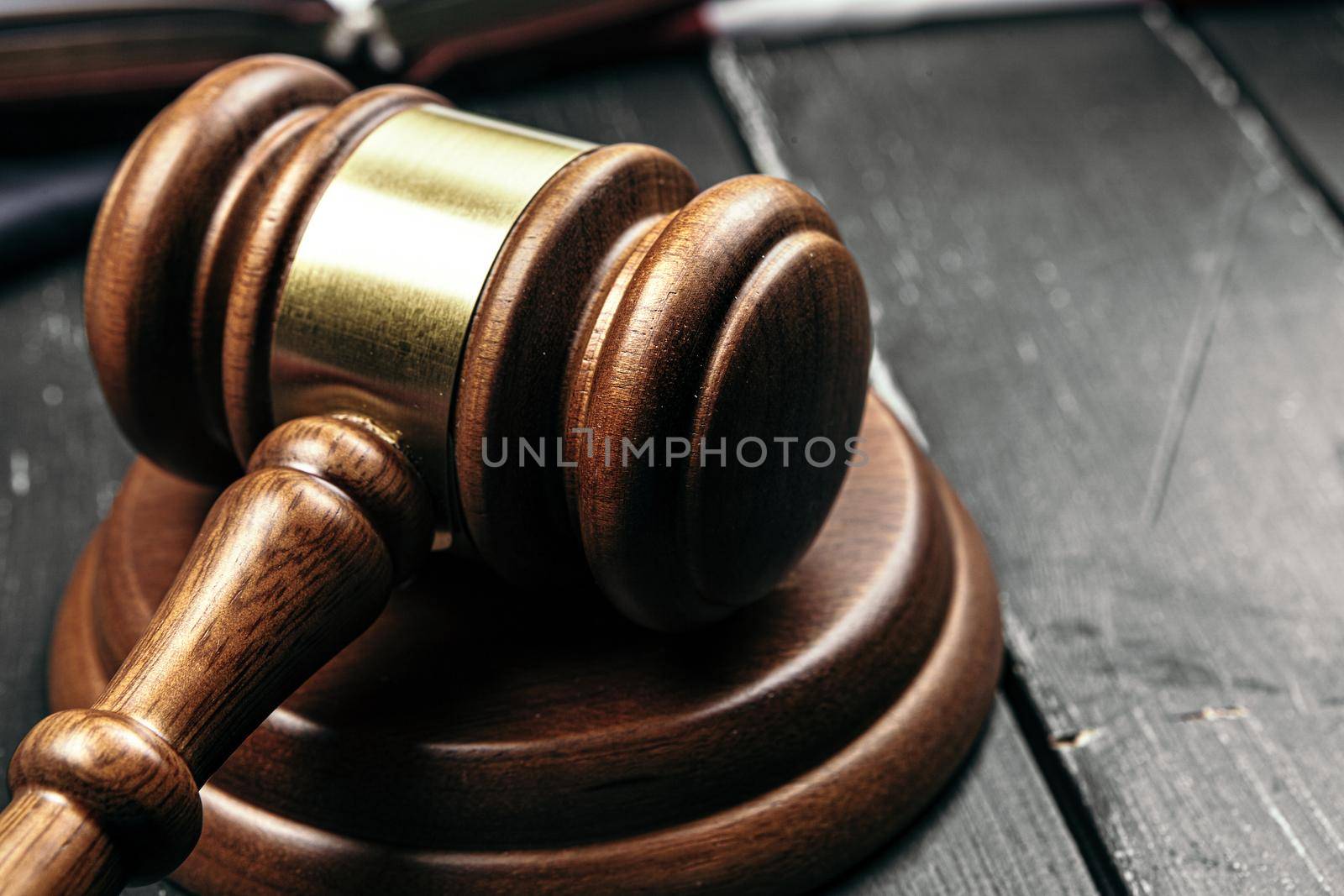 Judge's gavel on wooden table in dark. Close up.