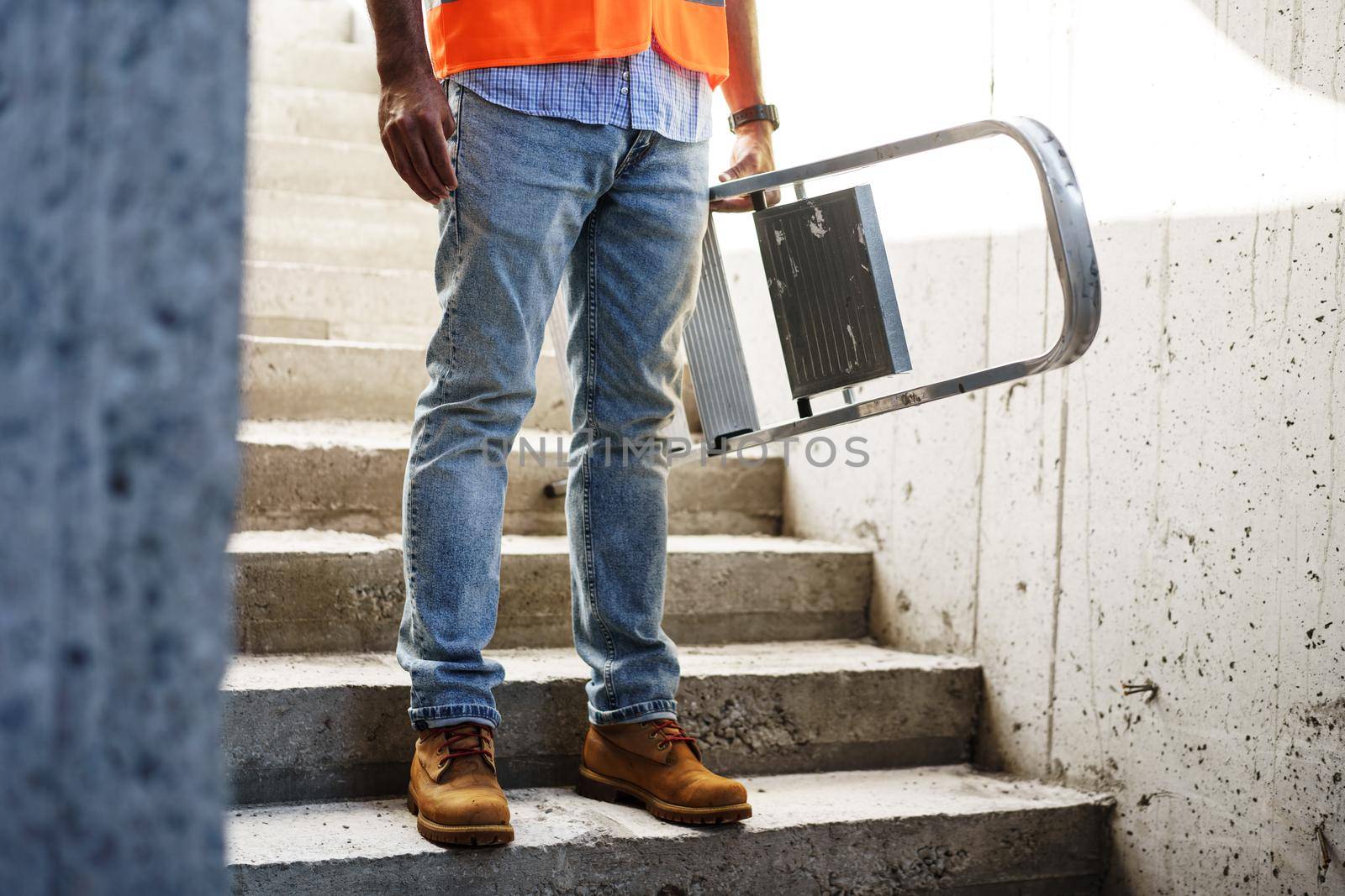 Professional builder carrying metal ladder, close up photo