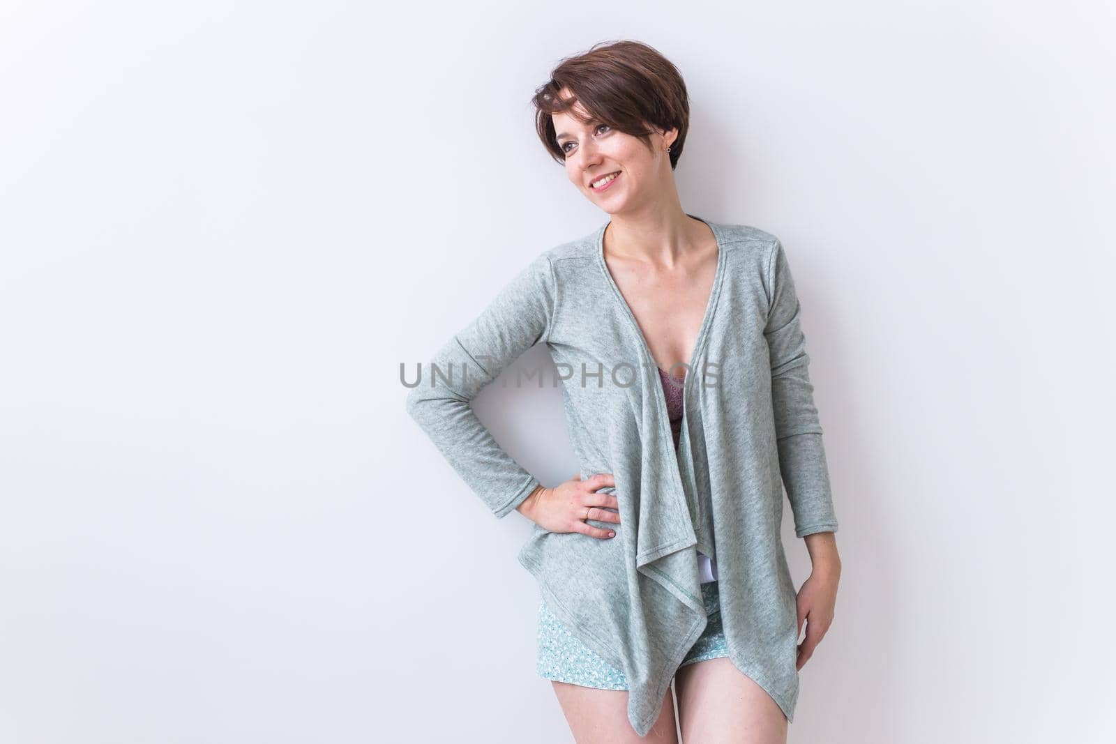 Beautiful young woman smiling against white background. Comfortable homewear, home relaxation and female fashion.