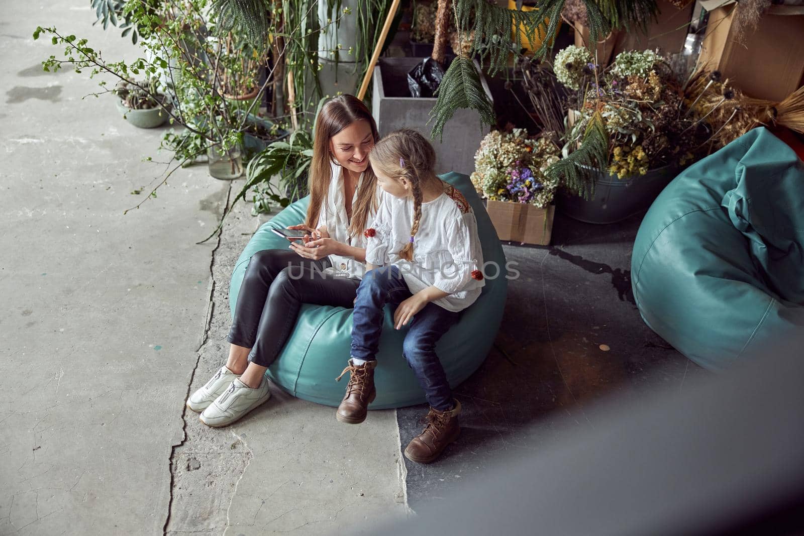 Happy caucasian mother with young beautiful cheerful daughter are having time together