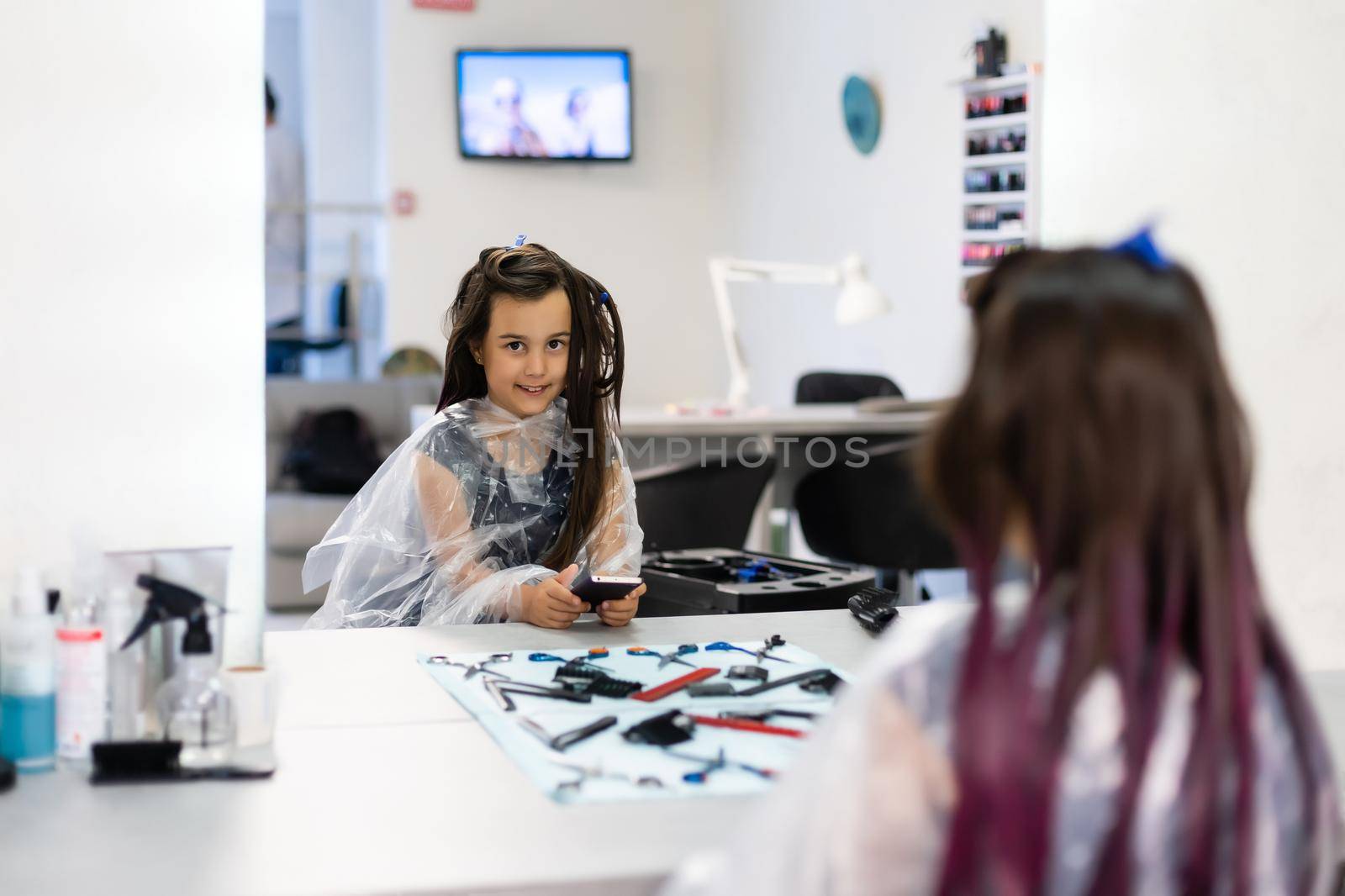 little girl dyes her hair purple in a hairdressing salon by Andelov13