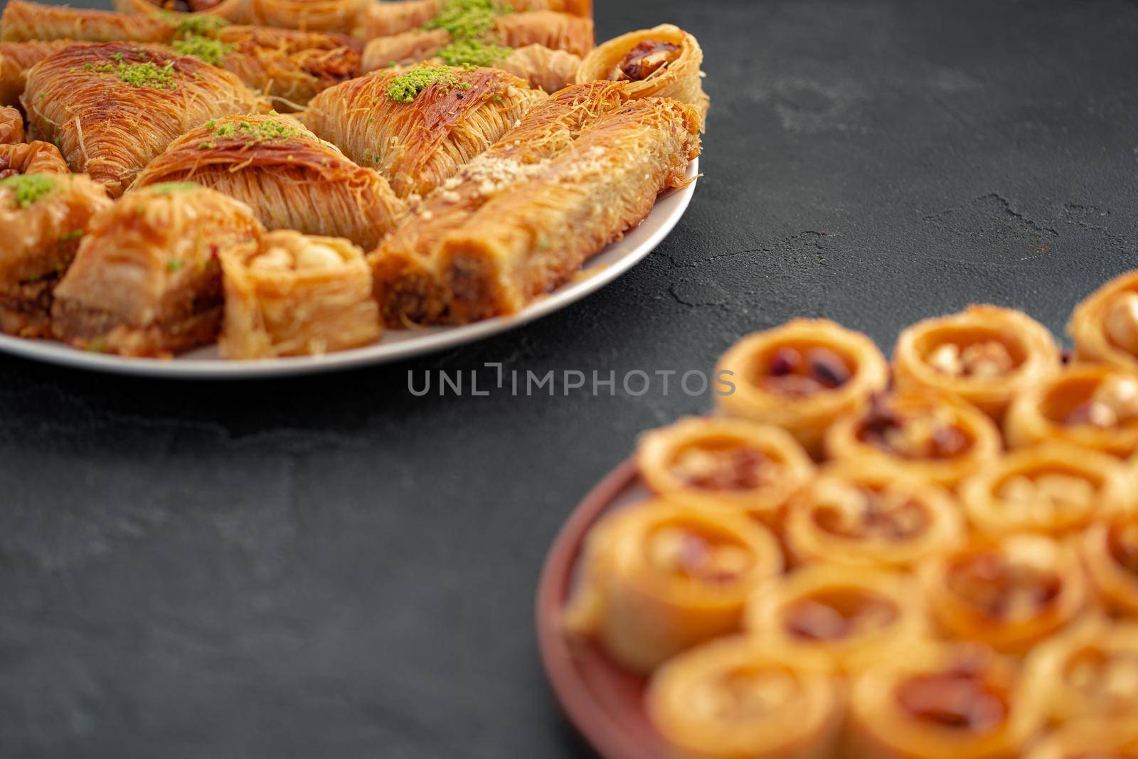 Delicious baklava dessert in oriental setting on black background, close up