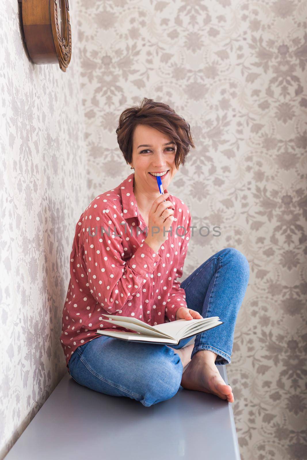 Girl sitting on chest of drawers at home