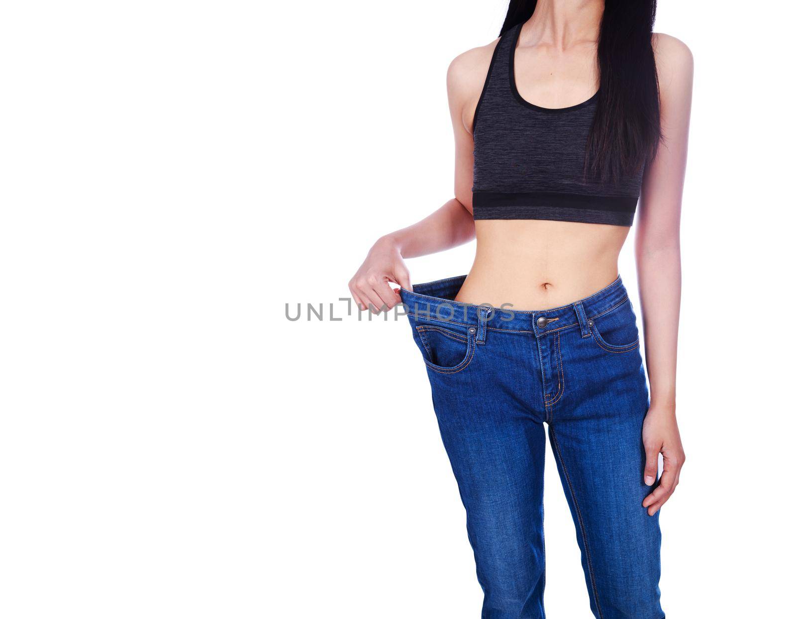 close up of woman show her weight loss and wearing her old jeans isolated on white background by geargodz