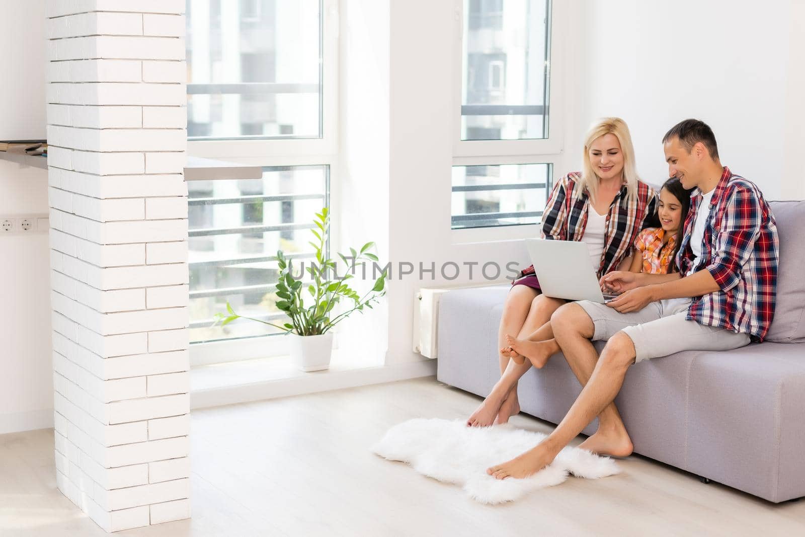 Happy family using laptop together on sofa in house