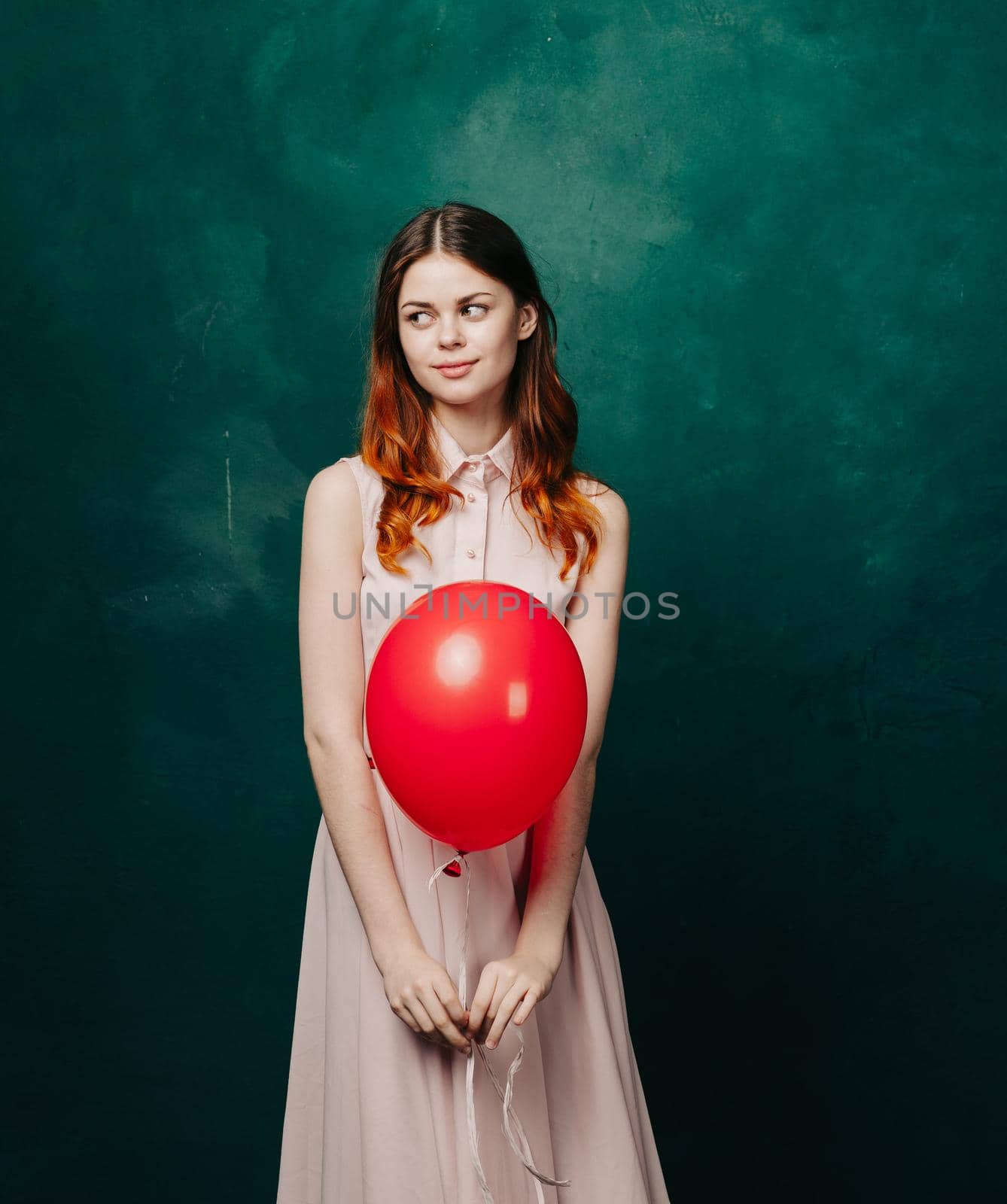 pretty woman in dress red balloon holiday green background. High quality photo