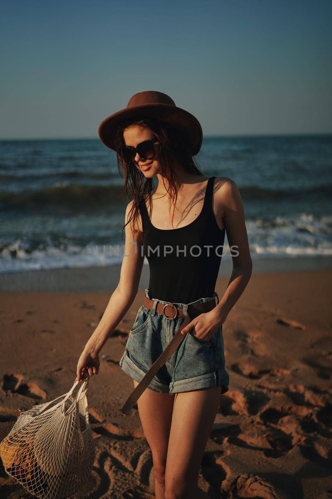 pretty woman in hat walking on the beach ocean travel. High quality photo