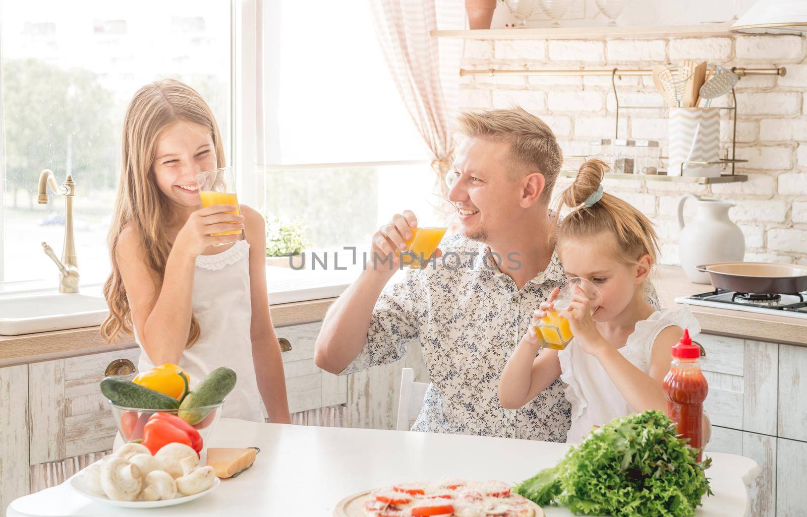 Dad with two daughters drinks juice by tan4ikk1