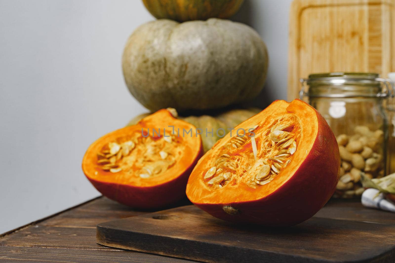 Pumpkin cut into halves on dark wooden table close up