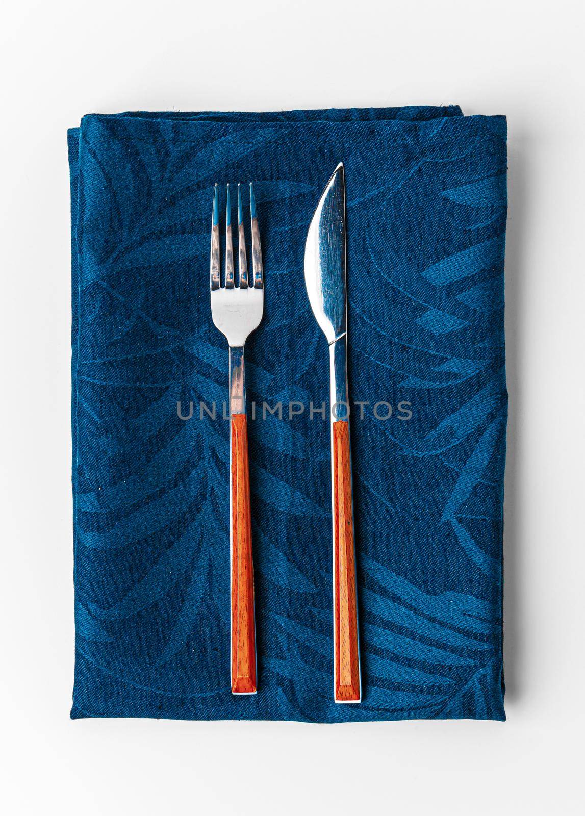 Set of fork and knife on towel. Isolated on white background. Close up.
