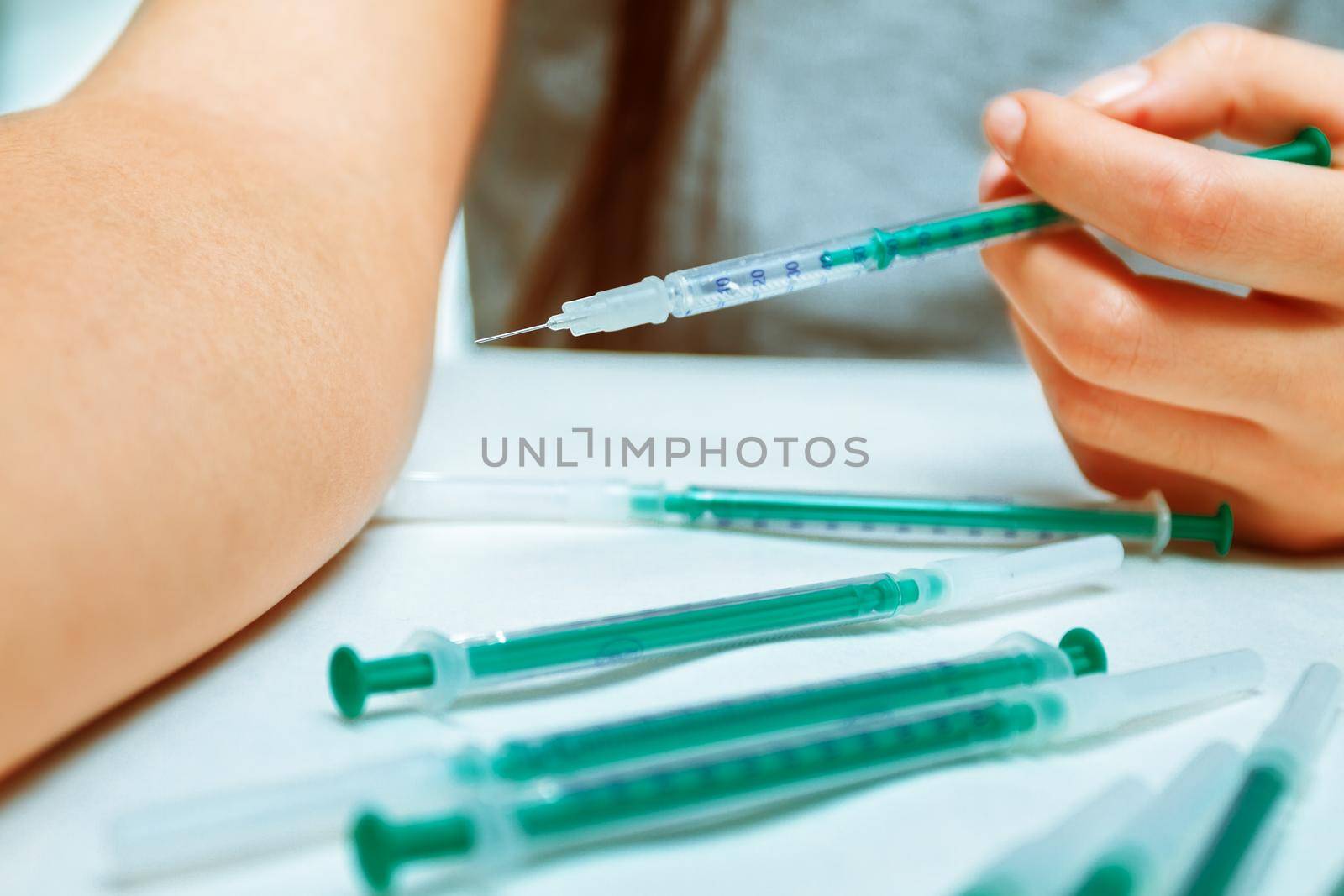Unrecognizable woman injects a drug through a syringe