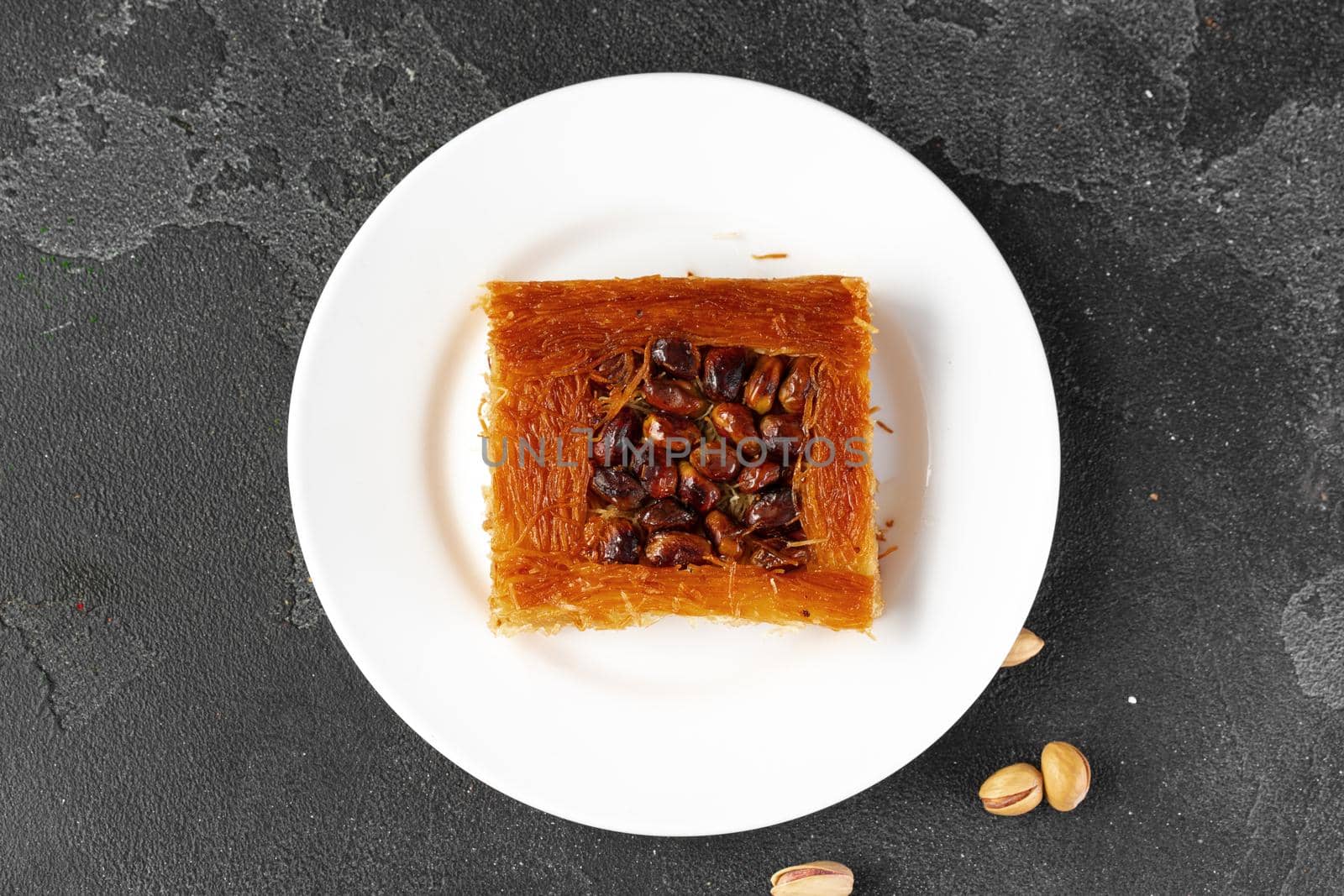 Turkish dessert baklava with nuts on black background, close up