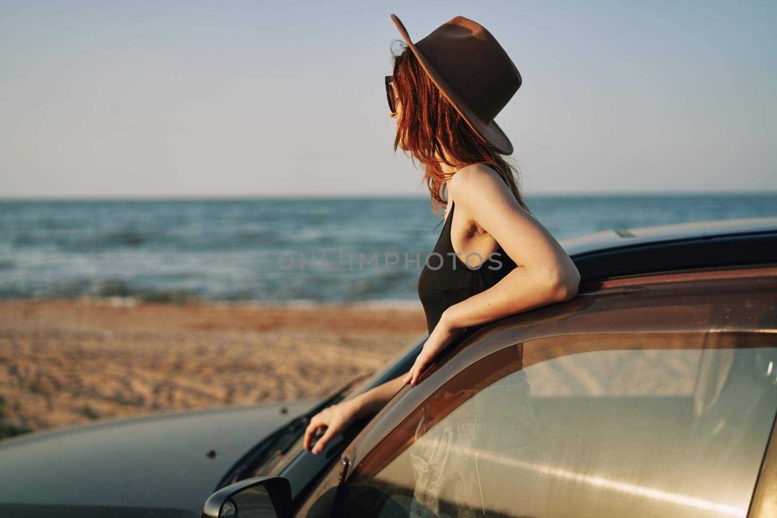 pretty woman in sunglasses near the car on the beach travel lifestyle. High quality photo