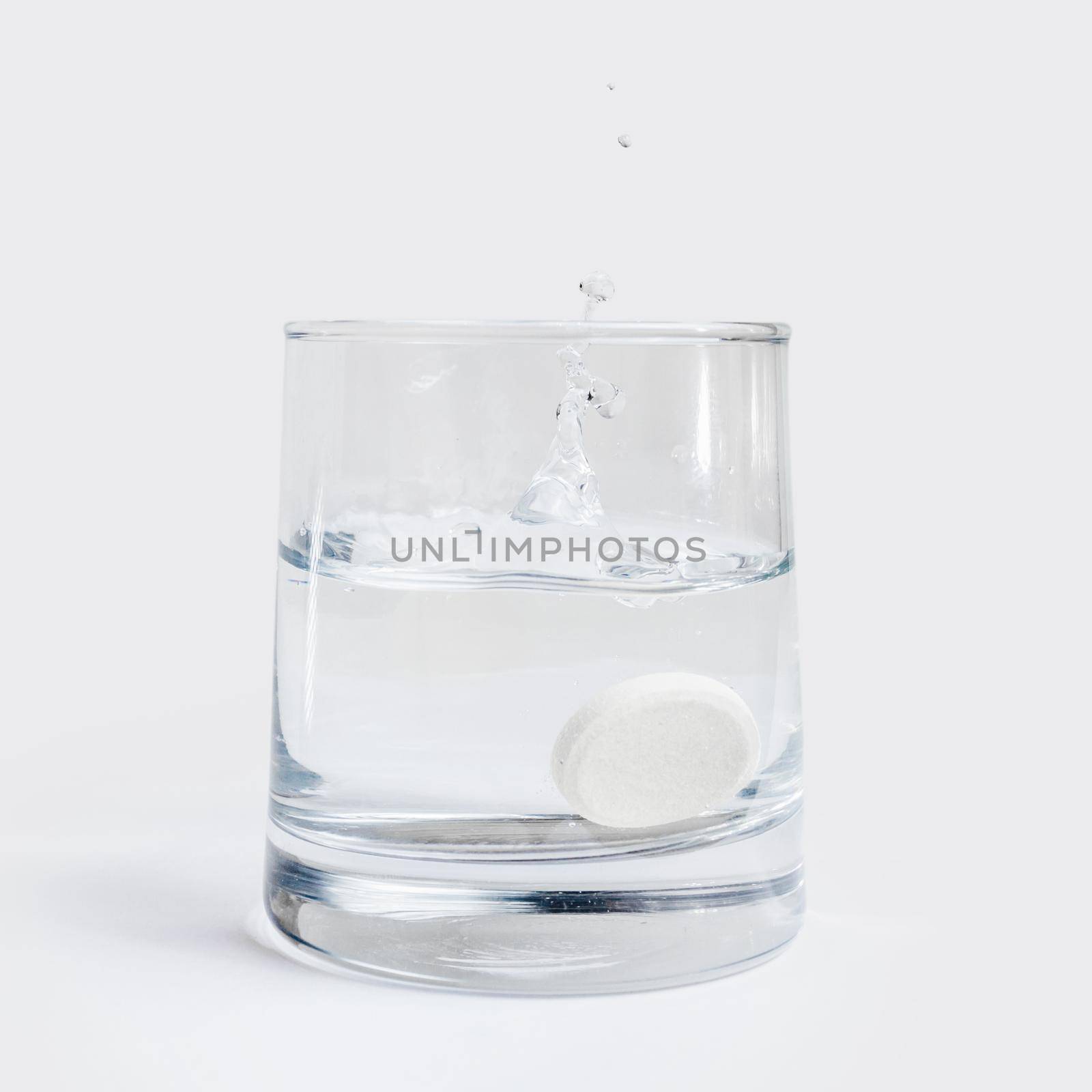Drug dissolved in a glass of water on a white table