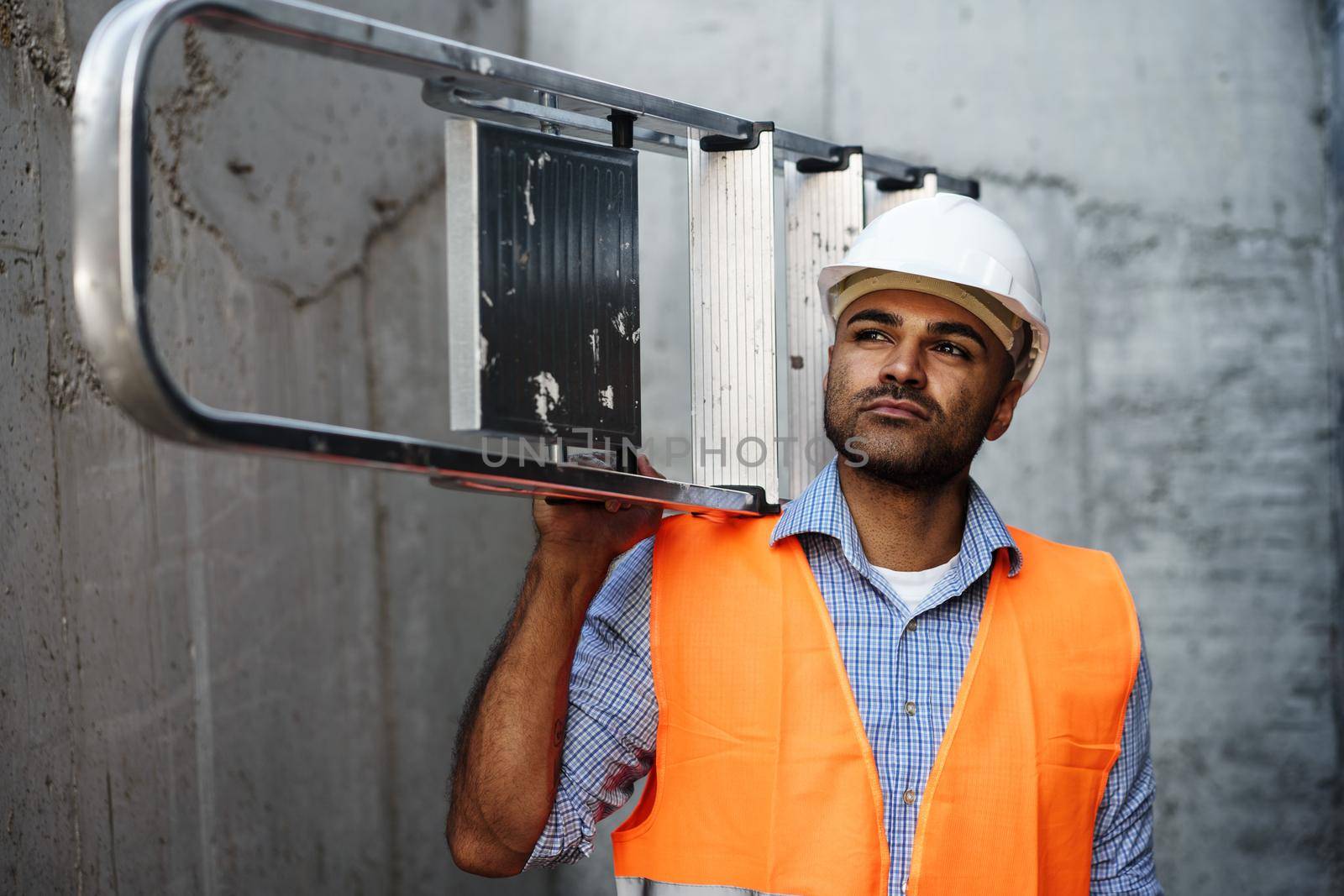 Professional builder carrying metal ladder, close up photo