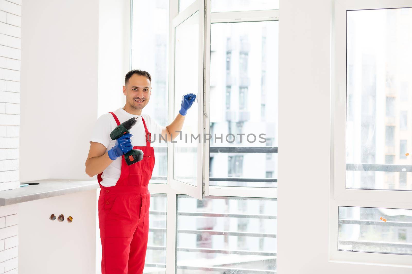 master with a screwdriver sets fittings on the window