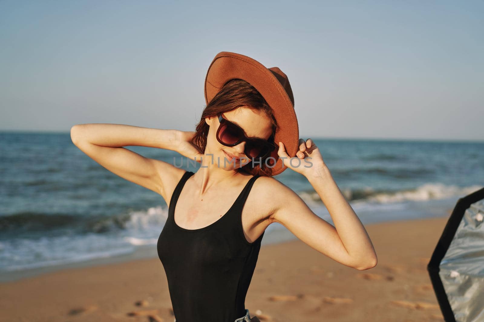 woman in a hat sunglasses by the ocean travel sun. High quality photo