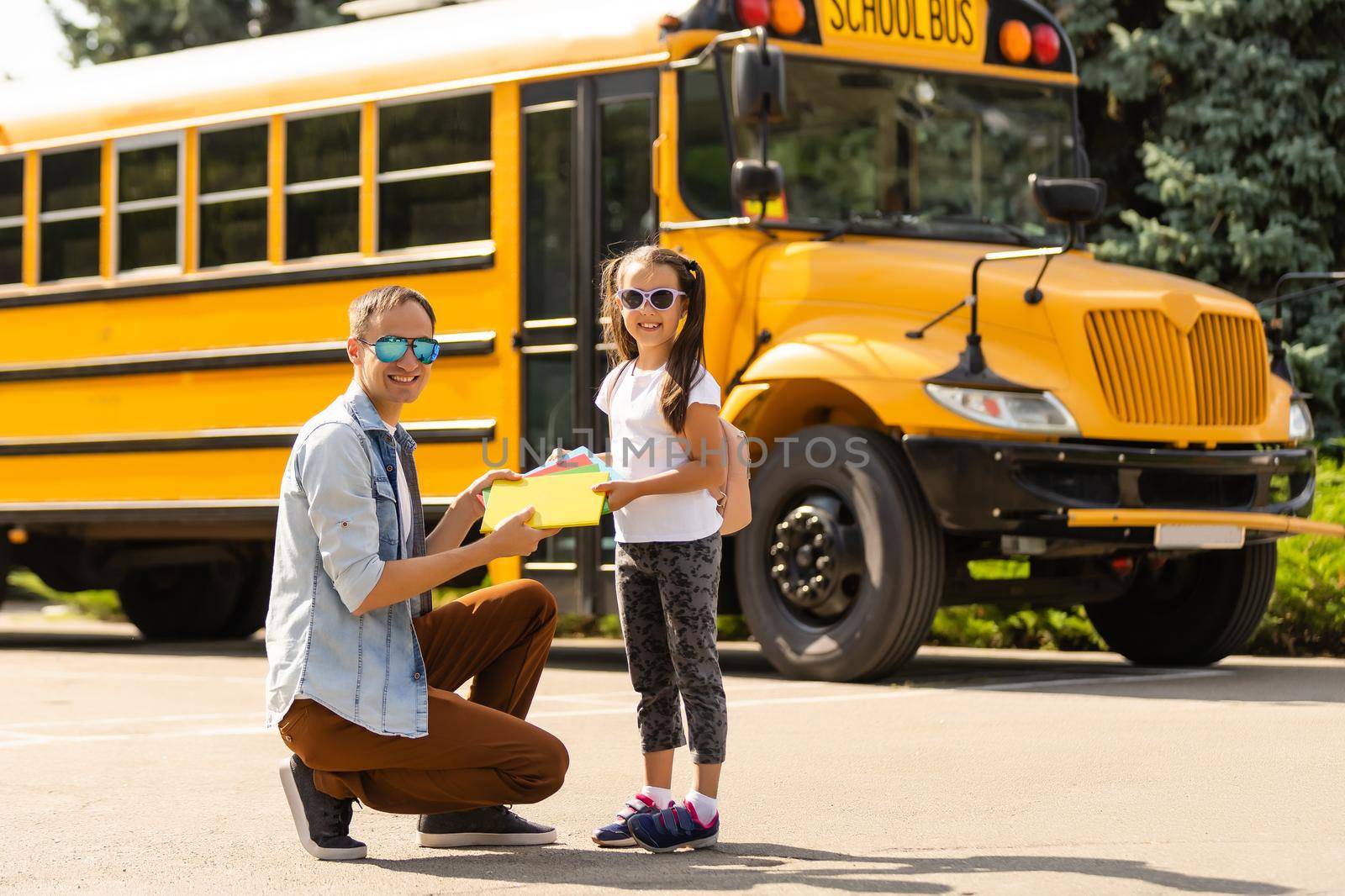 Girl with father going back to school near the school bus by Andelov13