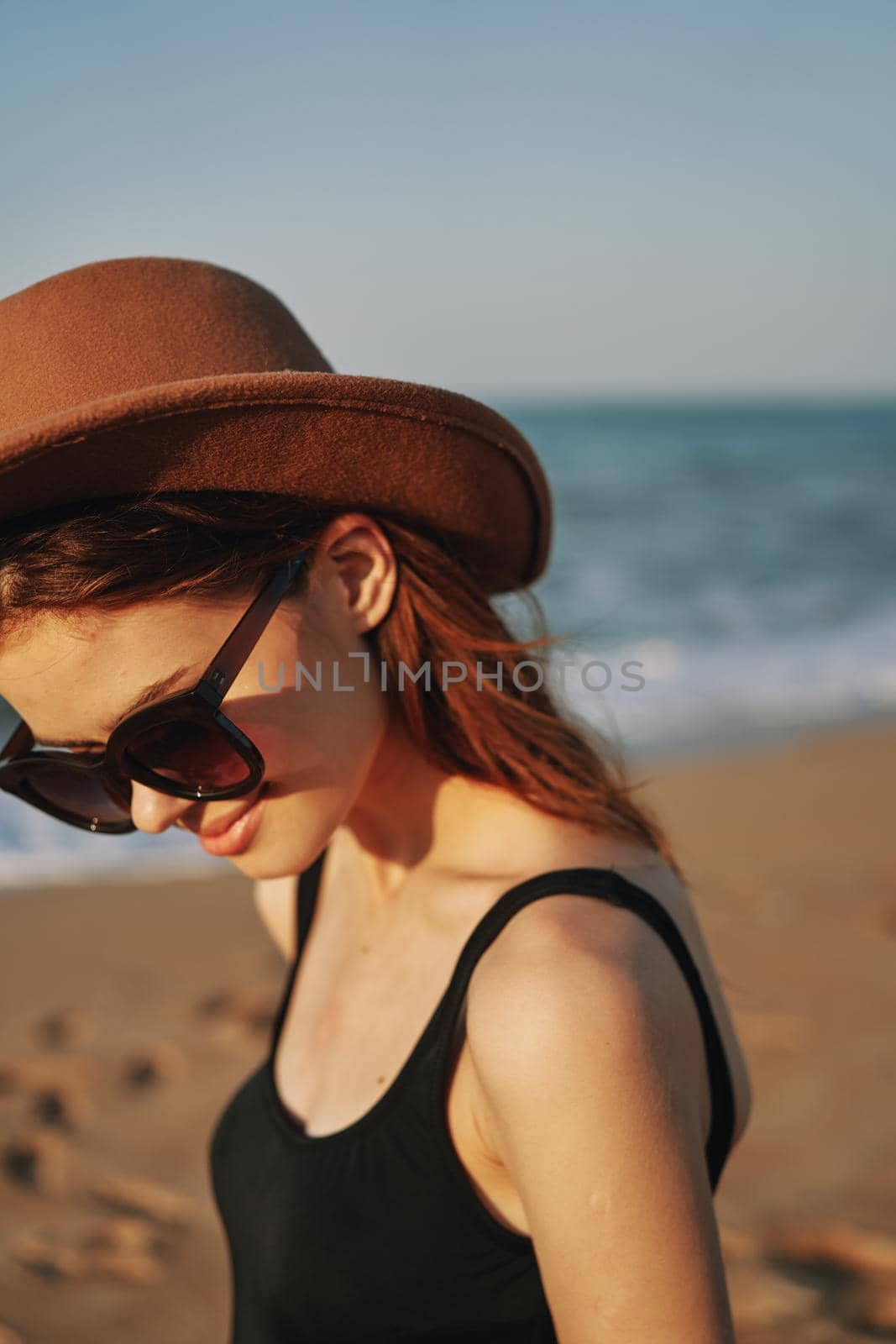 pretty woman in hat and sunglasses on the beach walk sun. High quality photo