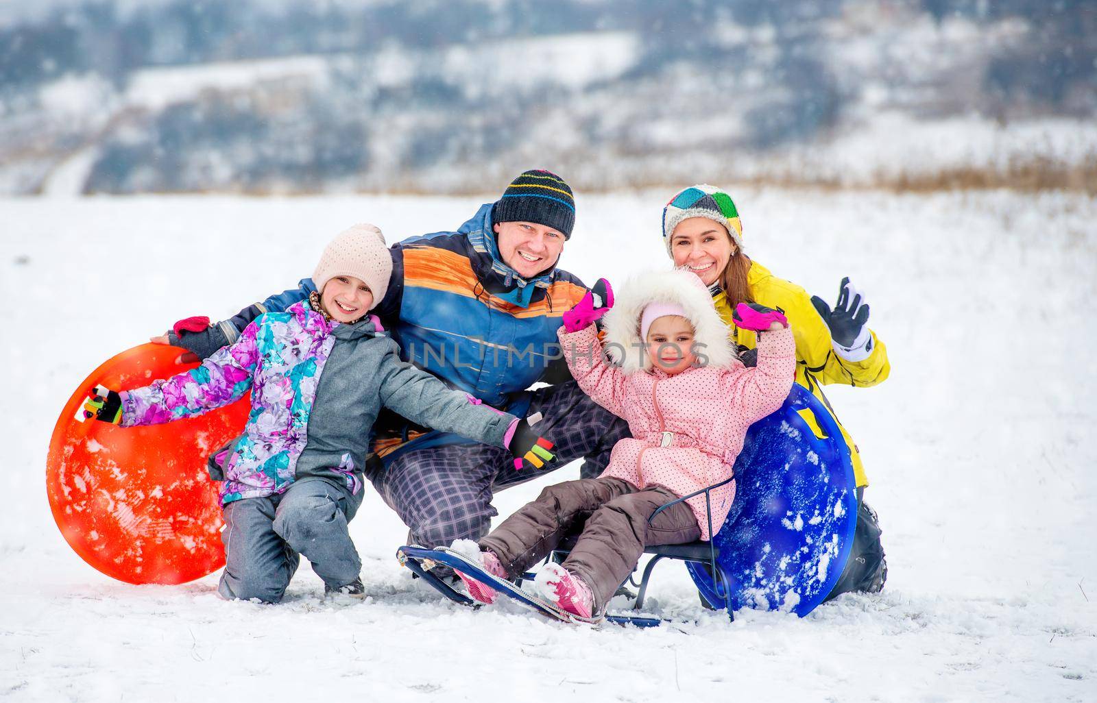 Active happy family smiling and laughing while playing outdoors during winter holidays. Winter fun outdoors with children