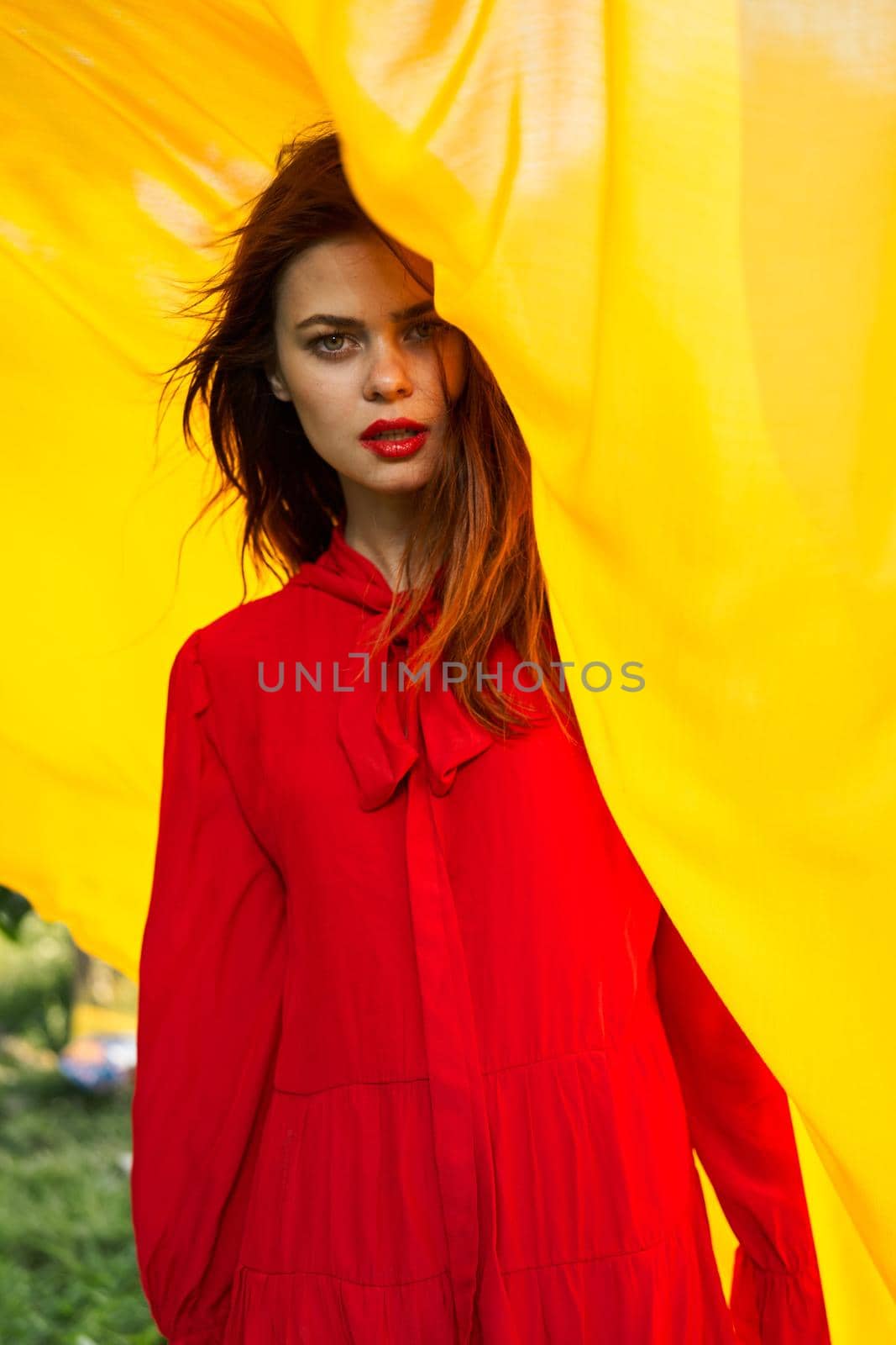 pretty woman in red dress nature yellow cloth on background. High quality photo