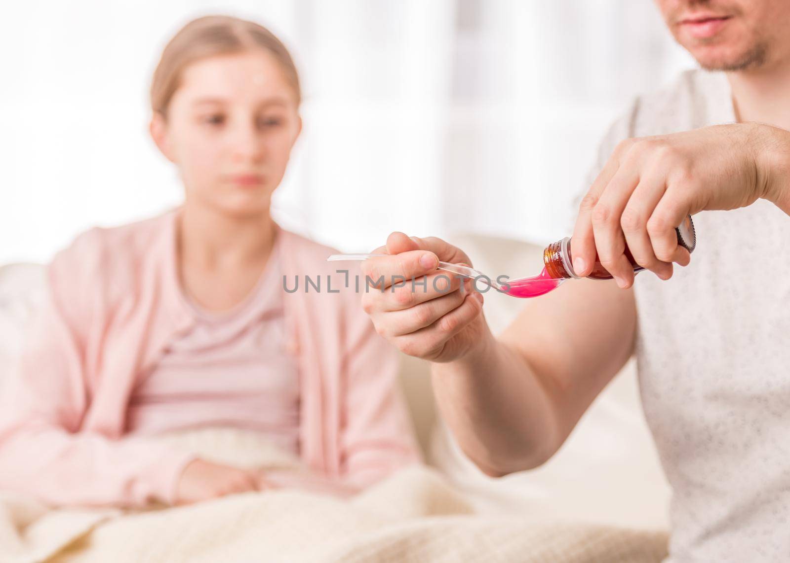 Loving father pouring effective medicine onto measuring spoon