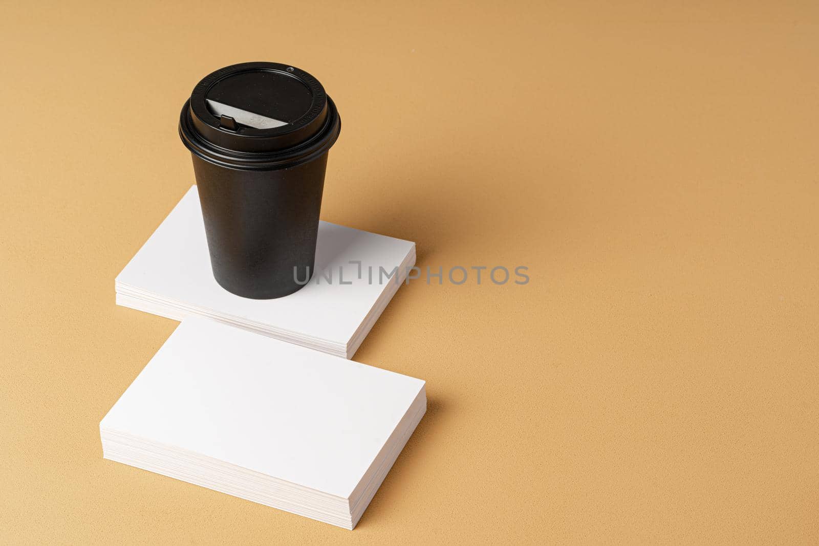 Blank takeaway coffee cup and white businesscards with copy space