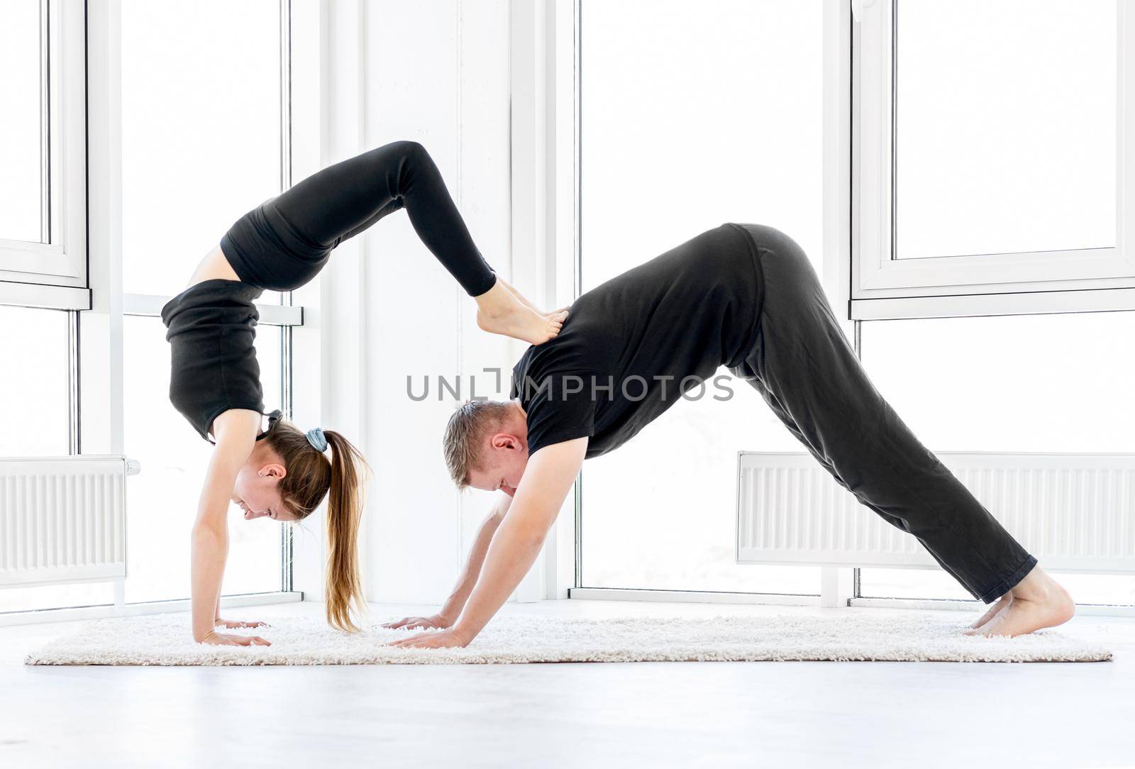 Sporty couple exercising acrobatics indoors