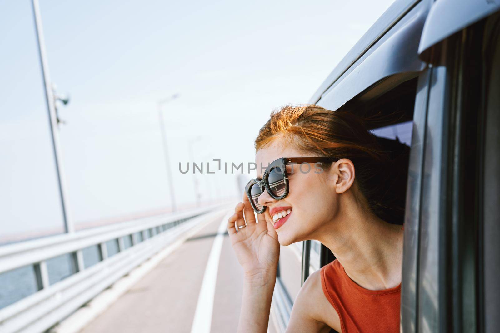 woman looking out of car window wearing sunglasses travel lifestyle. High quality photo