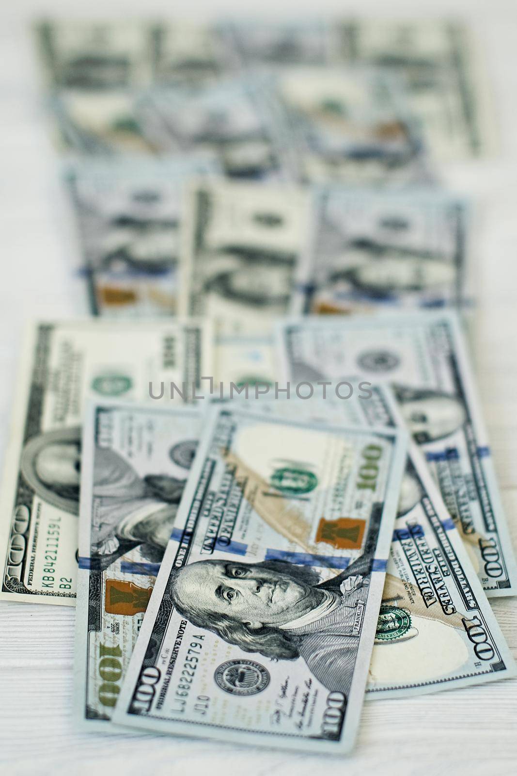 A stack of money. Heap of one hundred dollar bills on money background. Fake money. Shallow depth of field. Selective focus. by Maximusnd