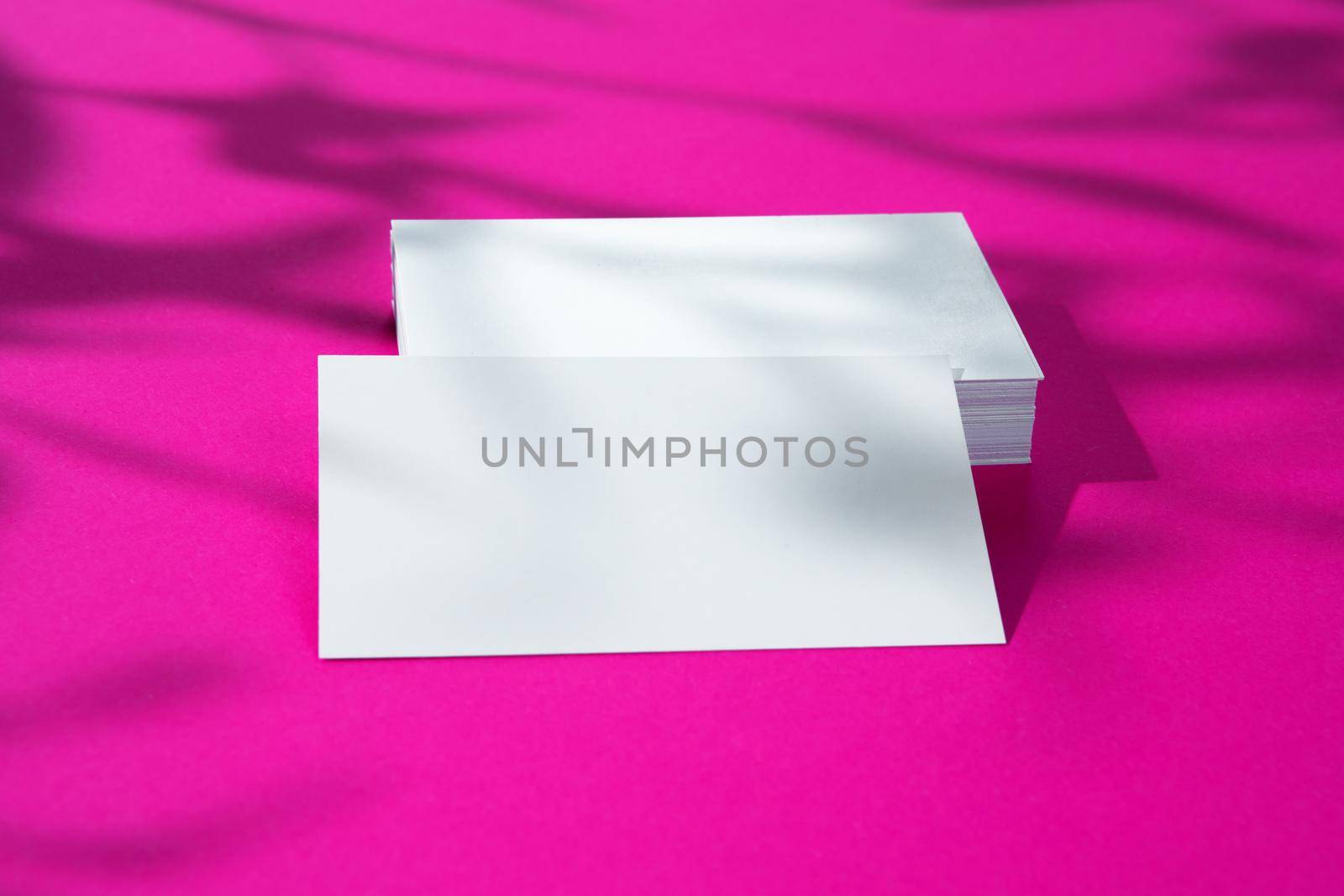 Advertising mock-up. White blank businesscards on bright pink background. copy space