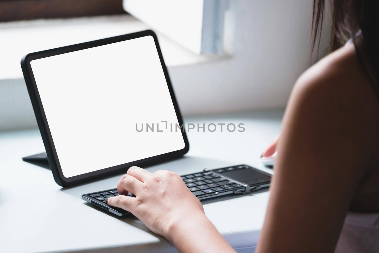 Business Women use a tablet for work, a blank tablet screen can add text or other media. by Manastrong