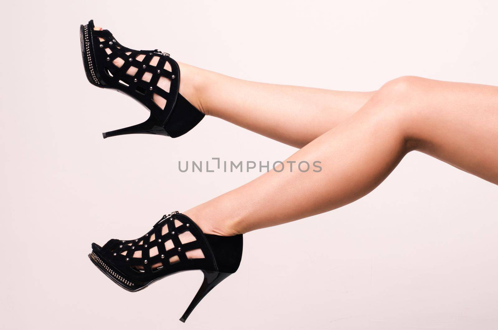 Long legs leggy woman wearing black fashion high heels sandals.