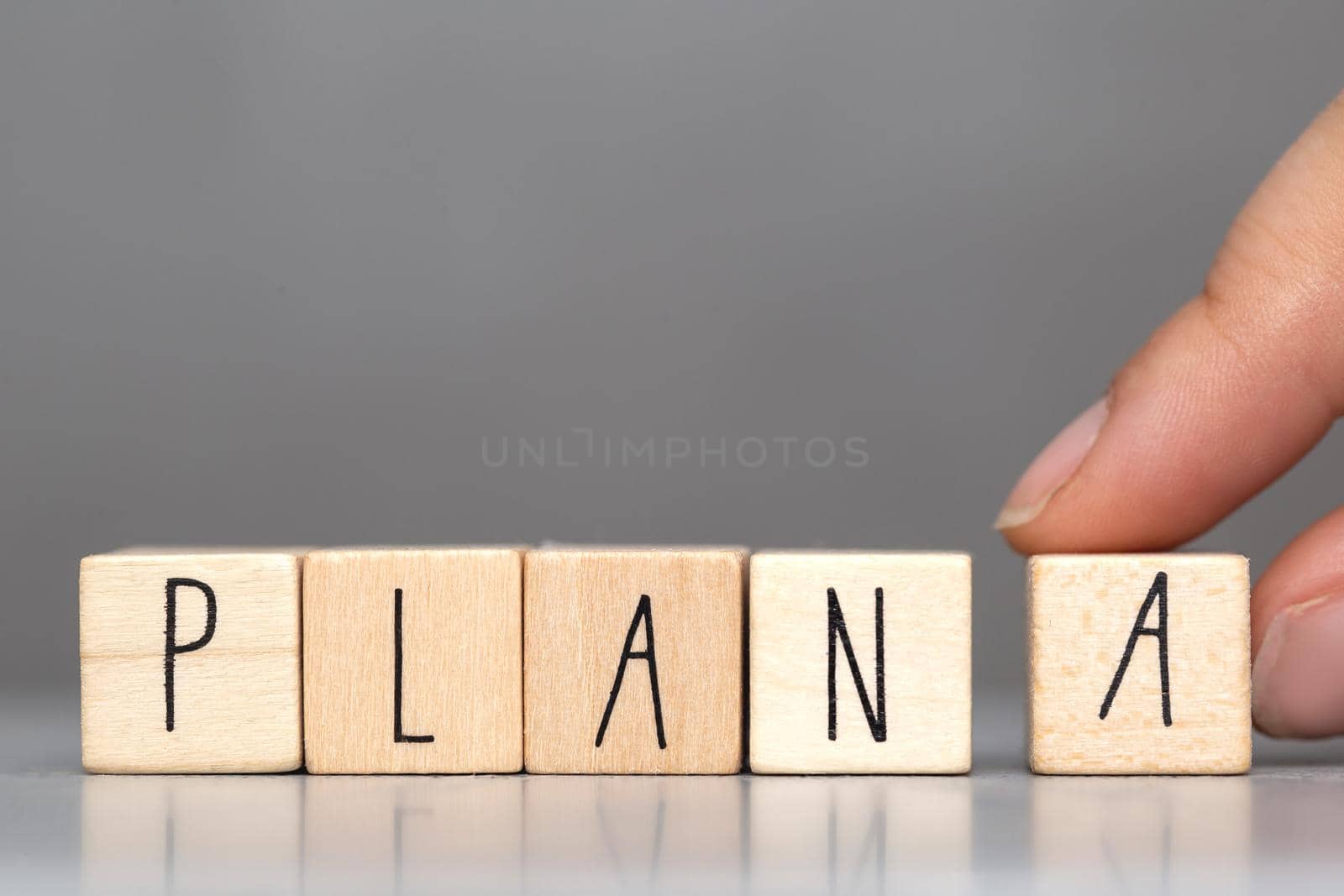 Wooden cube with PLAN A text on grey background. Goals, success, strategy, solution and business concepts close-up
