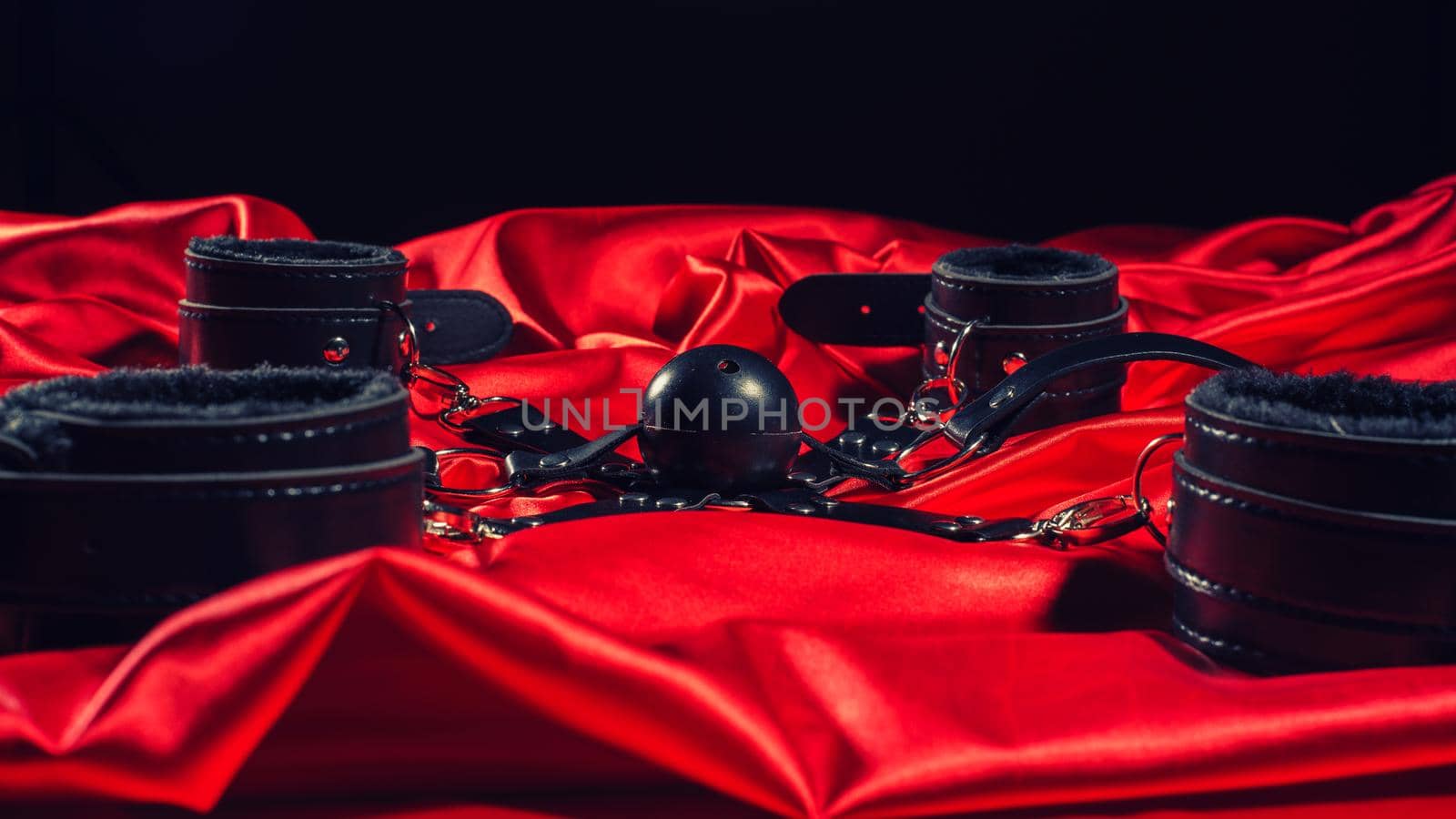 Bdsm outfit. Bondage and Gag ball on the red linen. Adult sex games. Kinky lifestyle. - image