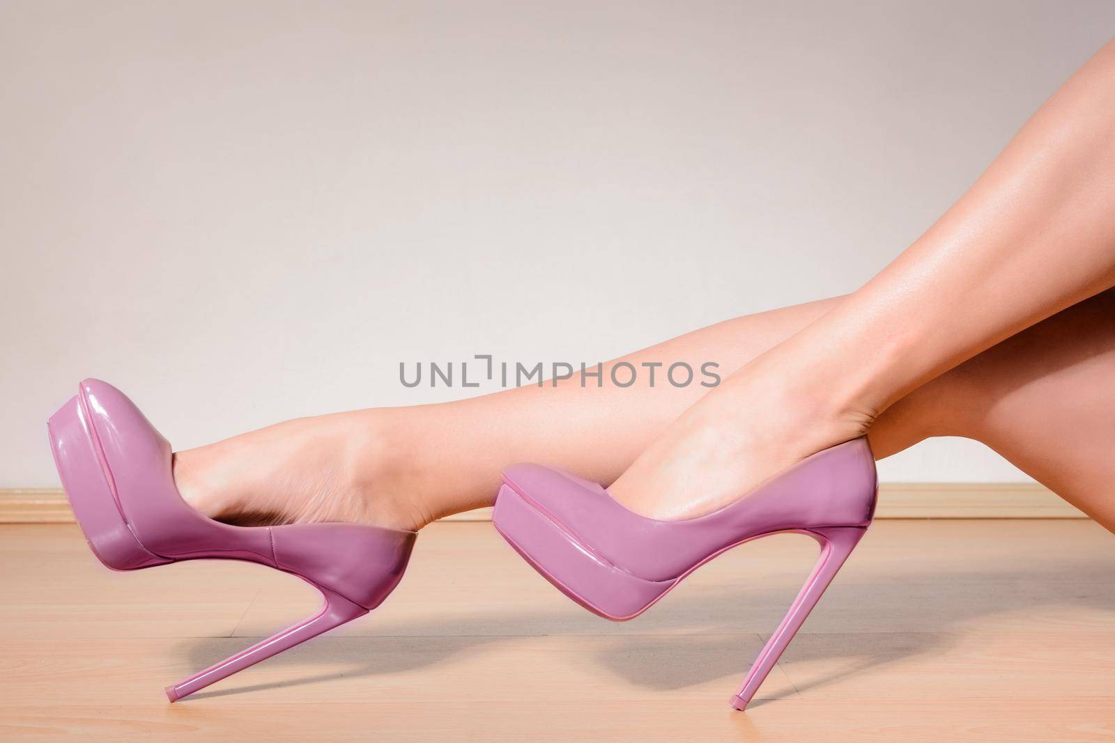 Purple high heels shoes on sexy female legs.