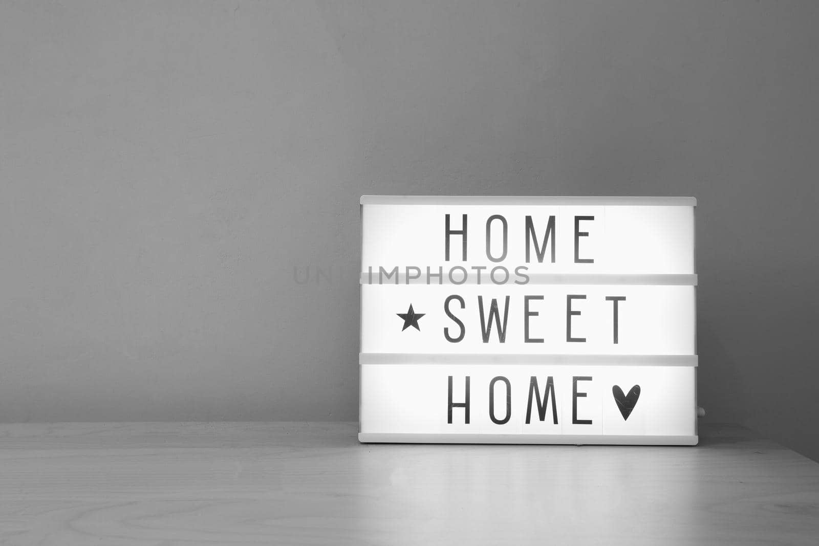 'Home sweet home' text in lighbox on wooden shelf, modern retro decoration purple wall