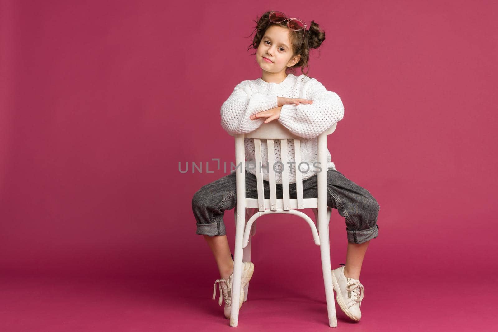 Photo of smiling little girl child isolated over pink background. Looking camera.