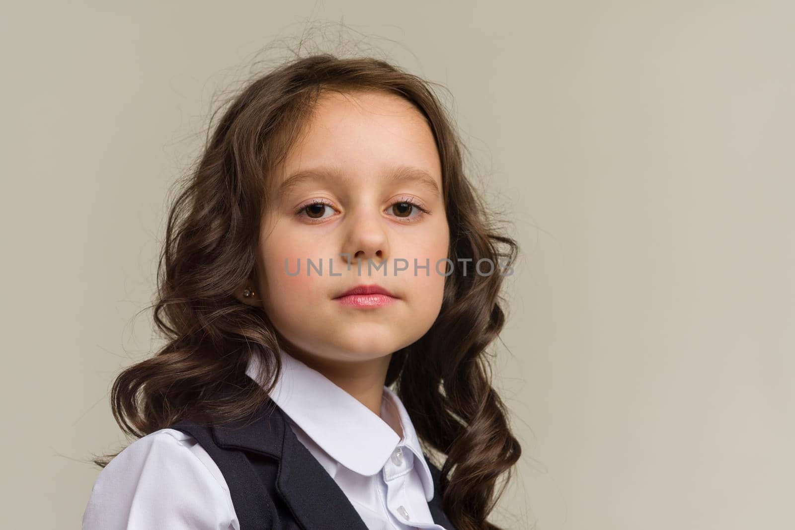 Photo of smiling little girl child isolated over grey background. Looking camera.