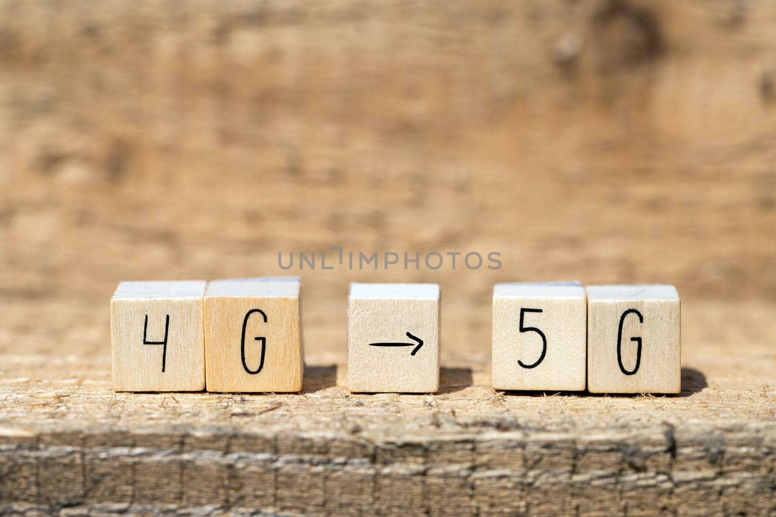 Wooden cubes From 4g To 5g with black arrow pointing On wooden background, mobile or technology concept closeup
