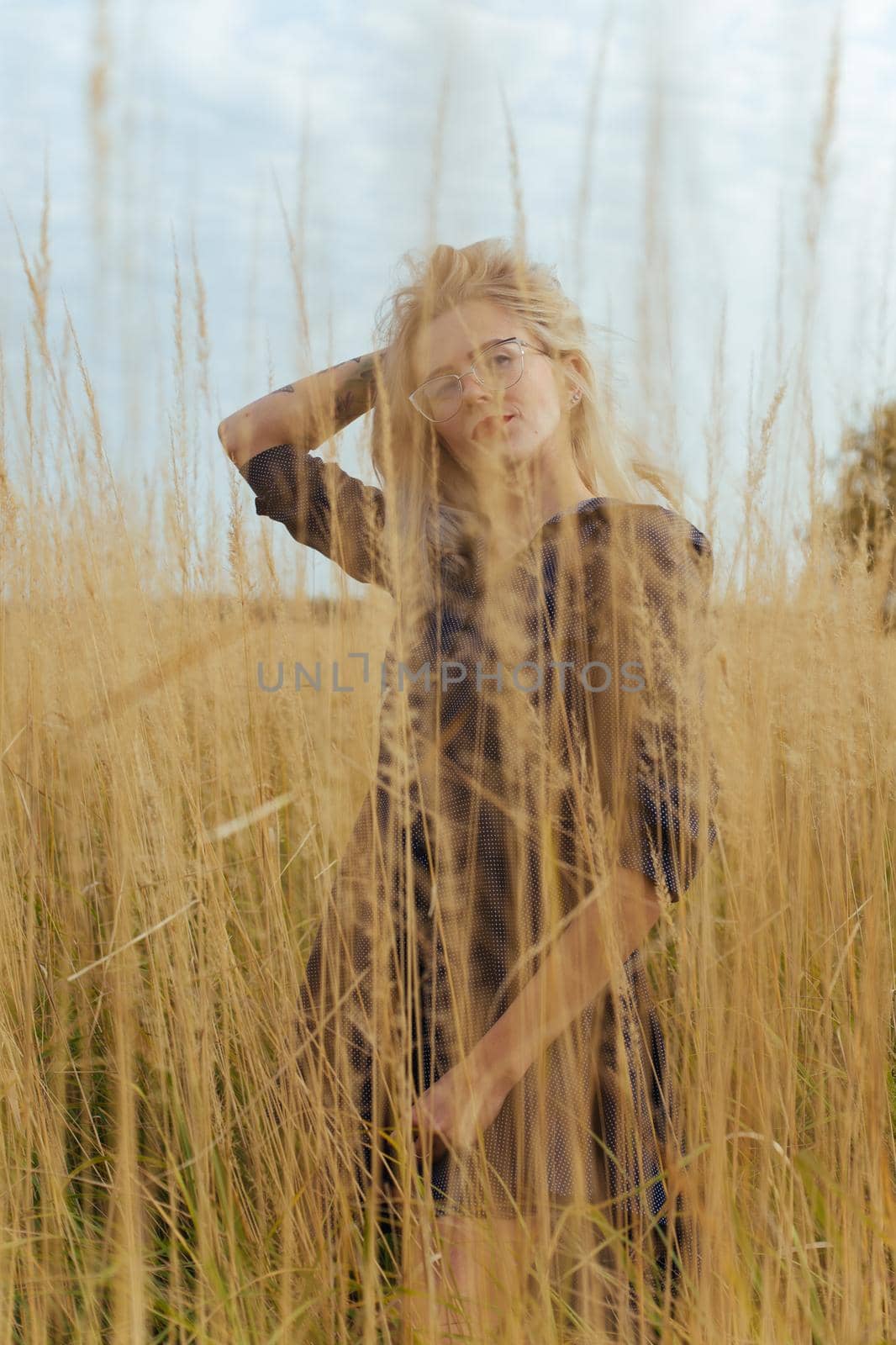 Beautiful girl villager posing in a dress in the field