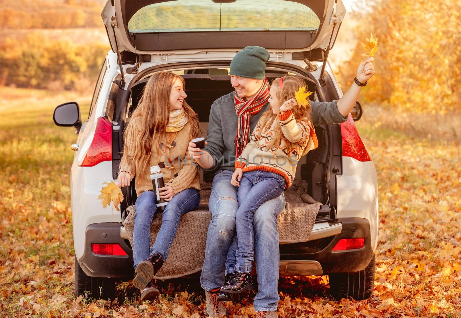 Smiling father with daughters in autumn surroundings